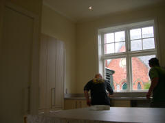 The sink is placed under the window, with dishwasher and stove under the bench to the right.